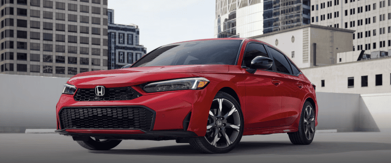 red honda civic parked on top of parkade with buildings in the background